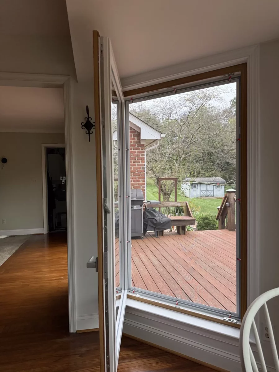 Tilted window installation in progress with view to outdoor deck
