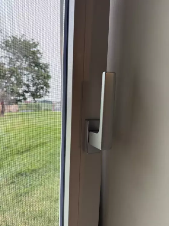Close-up of window handle and screen from inside