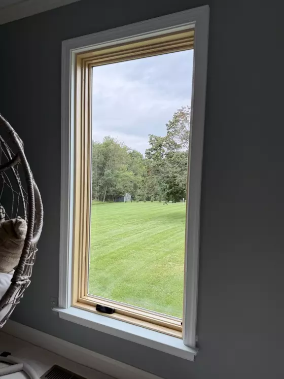 New Marvin Elevate casement window shown after full-frame replacement, with a natural-wood interior and finished white trim.