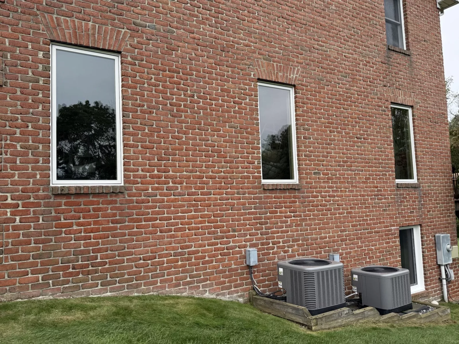 Four modern windows installed in a brick exterior wall