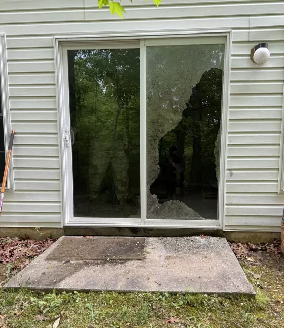 Shattered tempered glass on a sliding patio door before professional glass replacement in Aspen Hill, Maryland