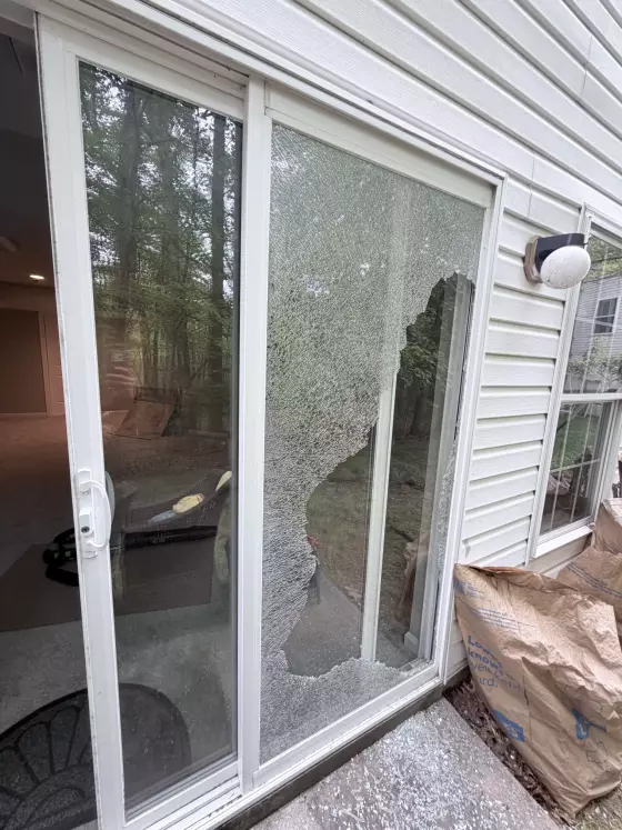 Shattered tempered glass on a sliding patio door before professional glass replacement in Aspen Hill, Maryland