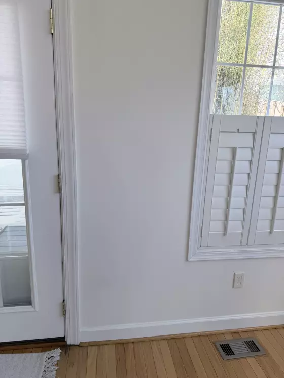 Interior view of a door and window with white trim and wood floor
